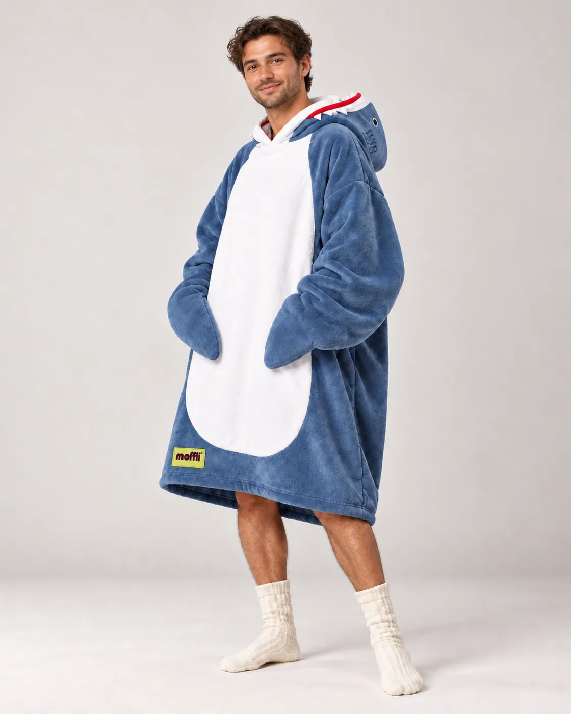 Smiling man full length wearing the blue Shark Moffli with white belly, shark mouth hood and fin sleeves