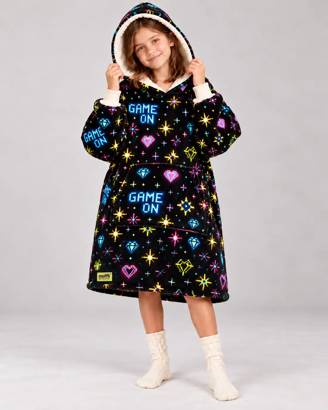 Girl standing wearing the Game On Moffli, cream sherpa-lined hood up
