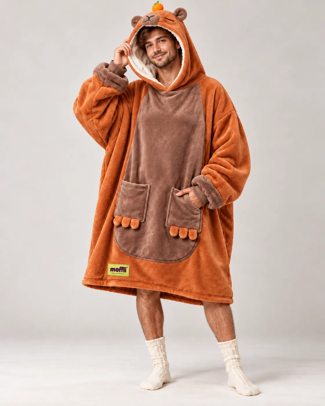 Smiling man full length wearing the Capybara Moffli, hood up with face, ears and mandarin, paw pockets