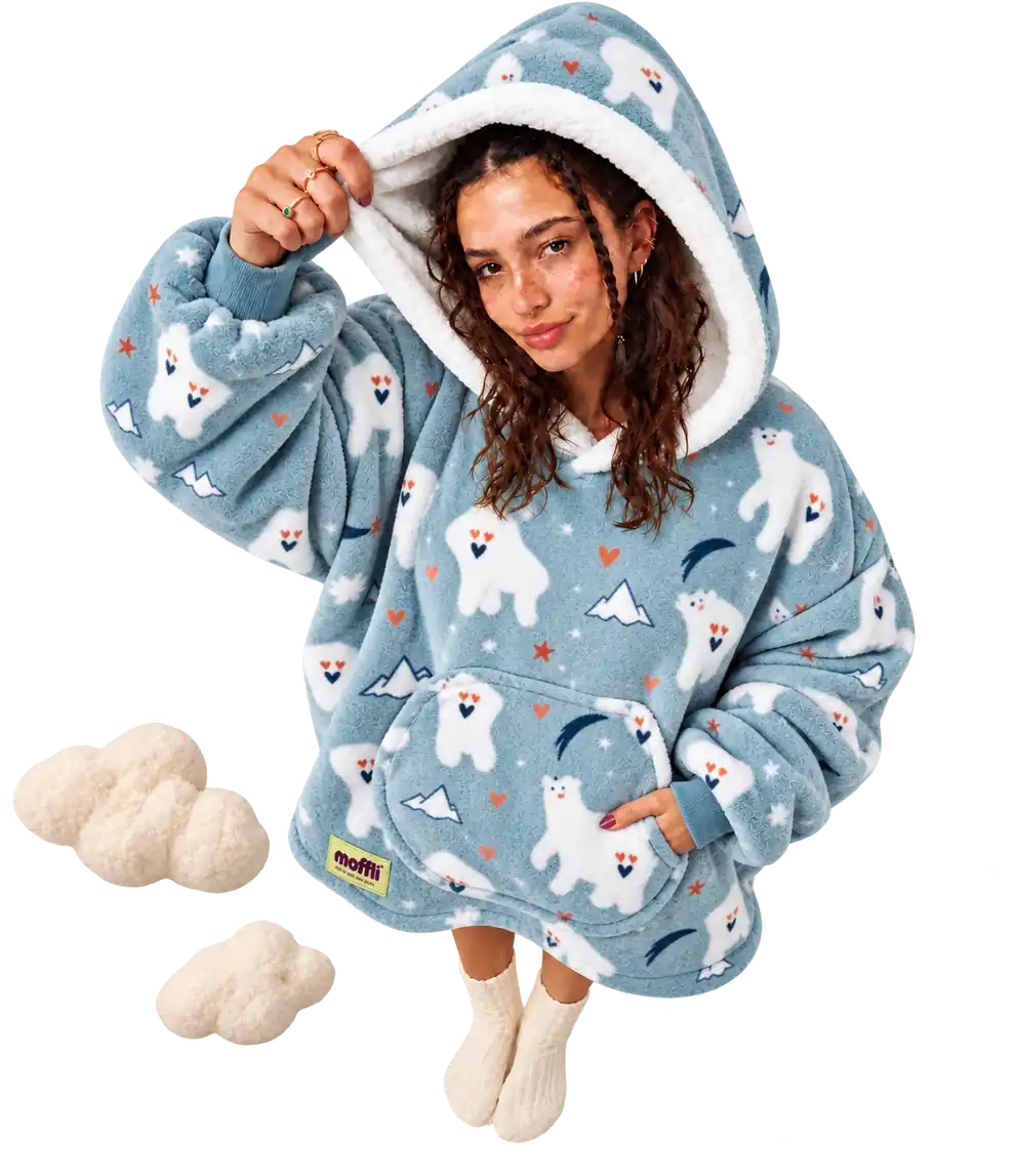Model wearing the blue Polar Bear Moffli lifting the white-lined hood, hand in the front pocket, next to two cream clouds