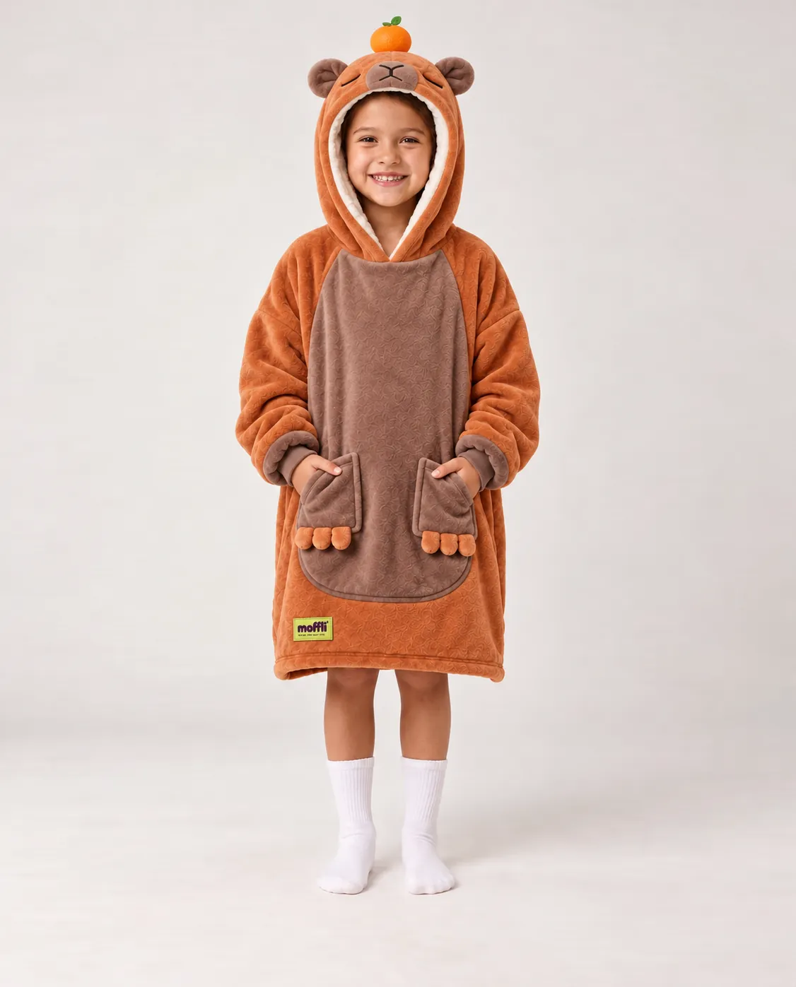 Boy and girl sitting on the sofa wearing the Capybara Kids Moffli and hood up with mandarin