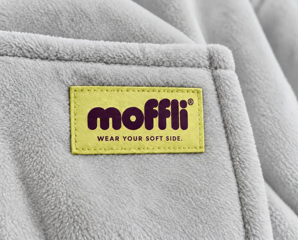 Macro of the grey fabric with pistachio moffli® "Wear your soft side." label