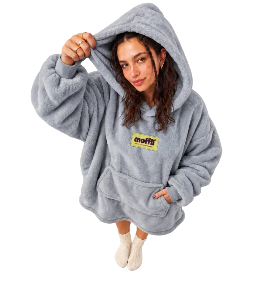 Model seen from above wearing the Cloud Grey Moffli, hood on with pistachio moffli® label and hand lifting the edge of the hood