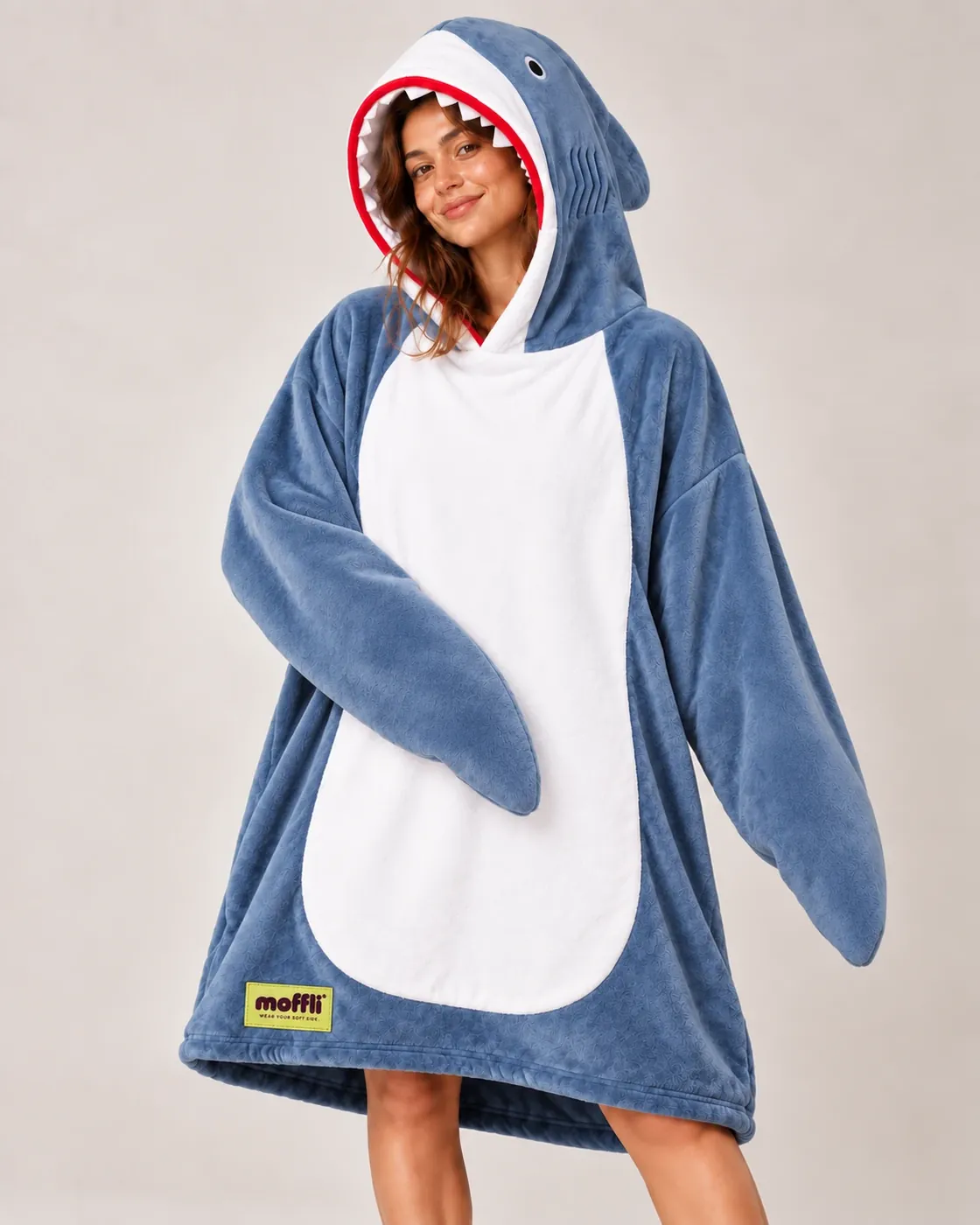 Smiling woman wearing the blue Shark Moffli, shark mouth hood and fin sleeves, front view