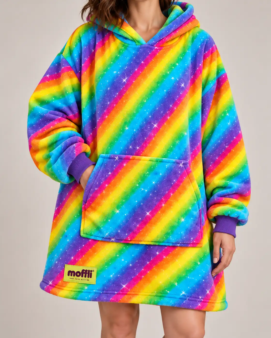 Primo piano dell'etichetta pistacchio Moffli "Wear your soft side." sul tessuto a righe arcobaleno