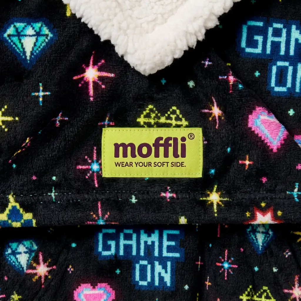 Detail of the black fabric of the Game On Kids Moffli with pixel print, Moffli label and sherpa lining